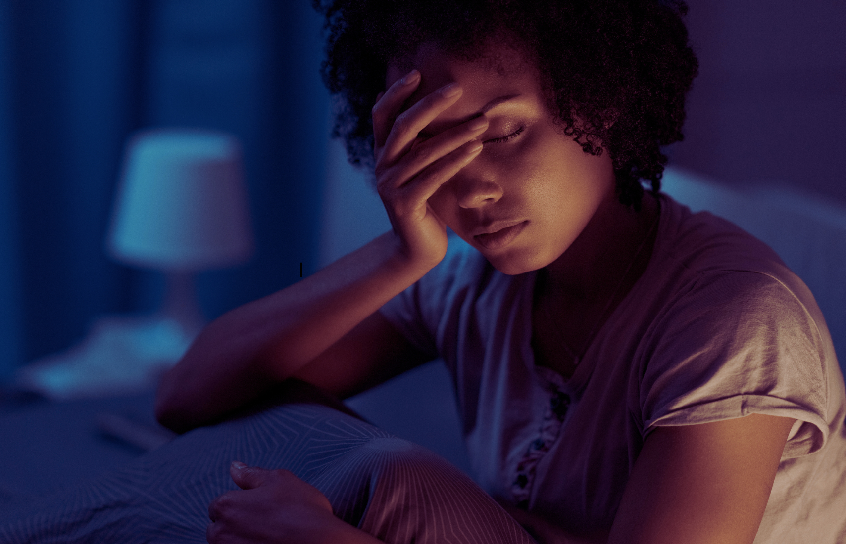 a woman holding her head and unable to sleep