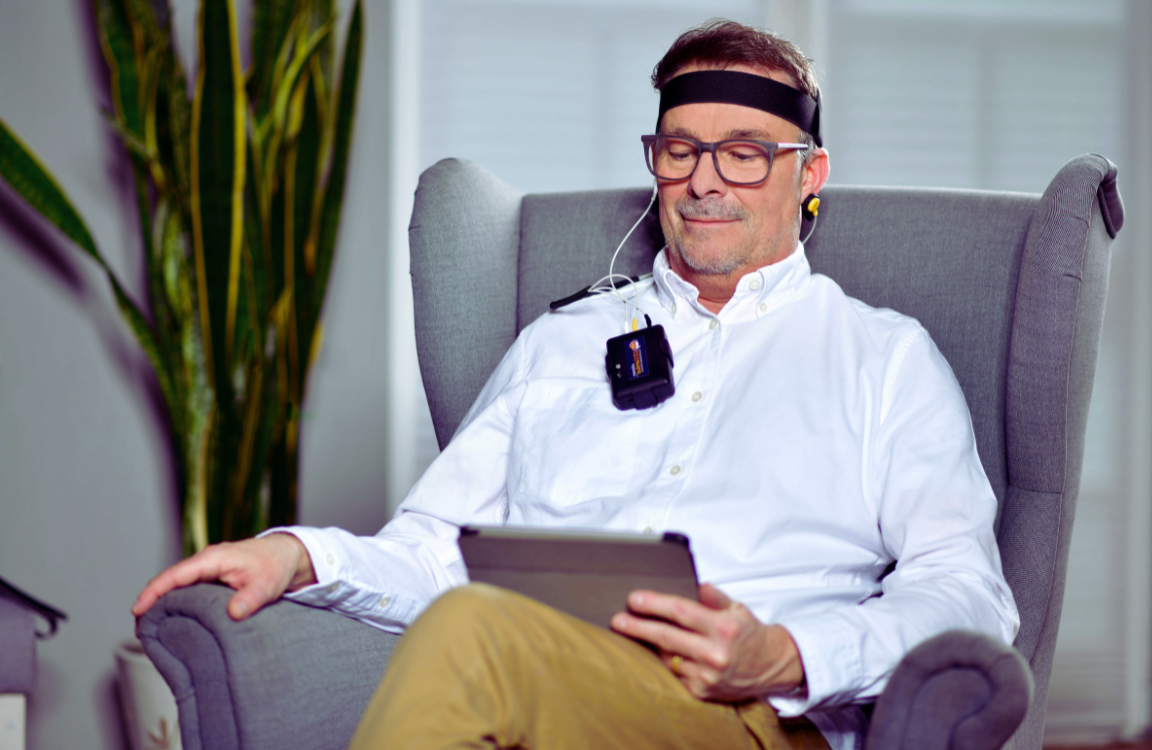 Neurofeedback therapy A man looking calm and focused while wearing a non-invasive neurofeedback headset during a wellness therapy session